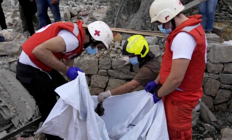 Voluntarios de la Cruz Roja libanesa y trabajadores de protección civil retiran los restos de varias personas asesinadas de los escombros de un edificio destruido el lunes por un ataque israelí en el poblado de Aito, en el norte del Líbano, el martes 15 de octubre de 2024. (AP Foto/Hussein Malla)