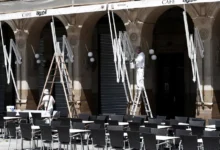 Dos empleados limpian y pintan el exterior de una cafetería en Pamplona, en una imagen de archivo. EFE/ Jesús Diges