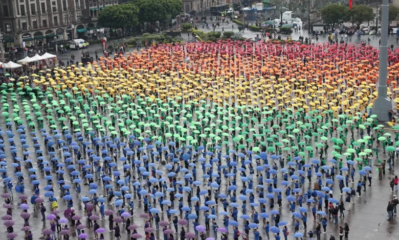 Miles de personas participan en la formación de una bandera monumental en el marco de 'La Semana del Orgullo' en el Zócalo de Ciudad de México. EFE/ Mario Guzmán